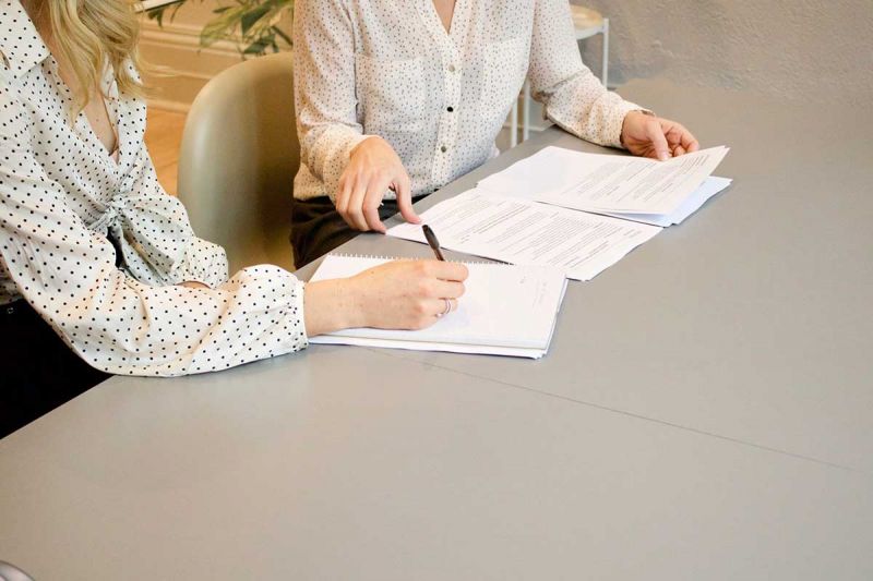 Businesswomen signing papers